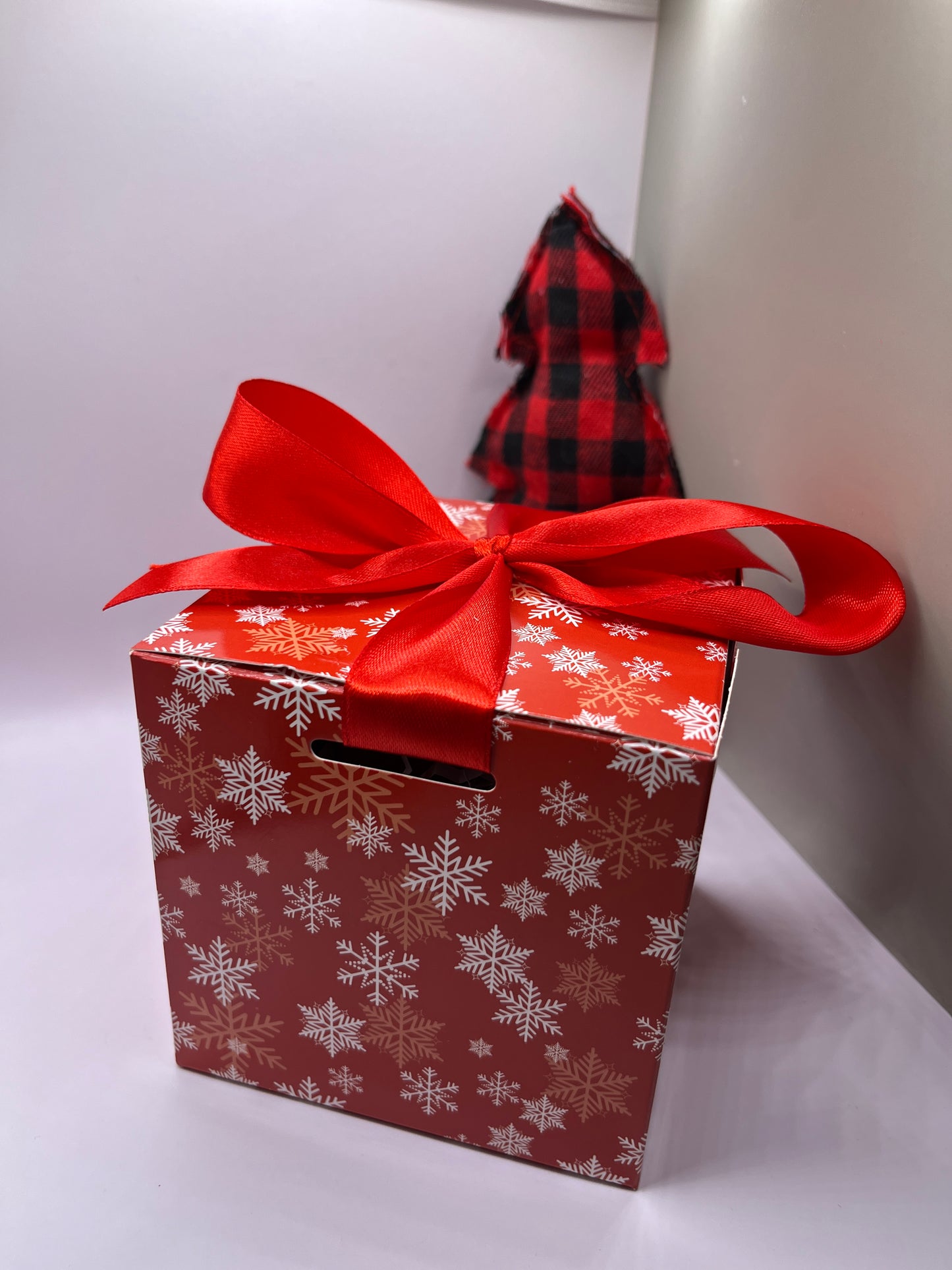 Red square box with snowflakes and red ribbon. 