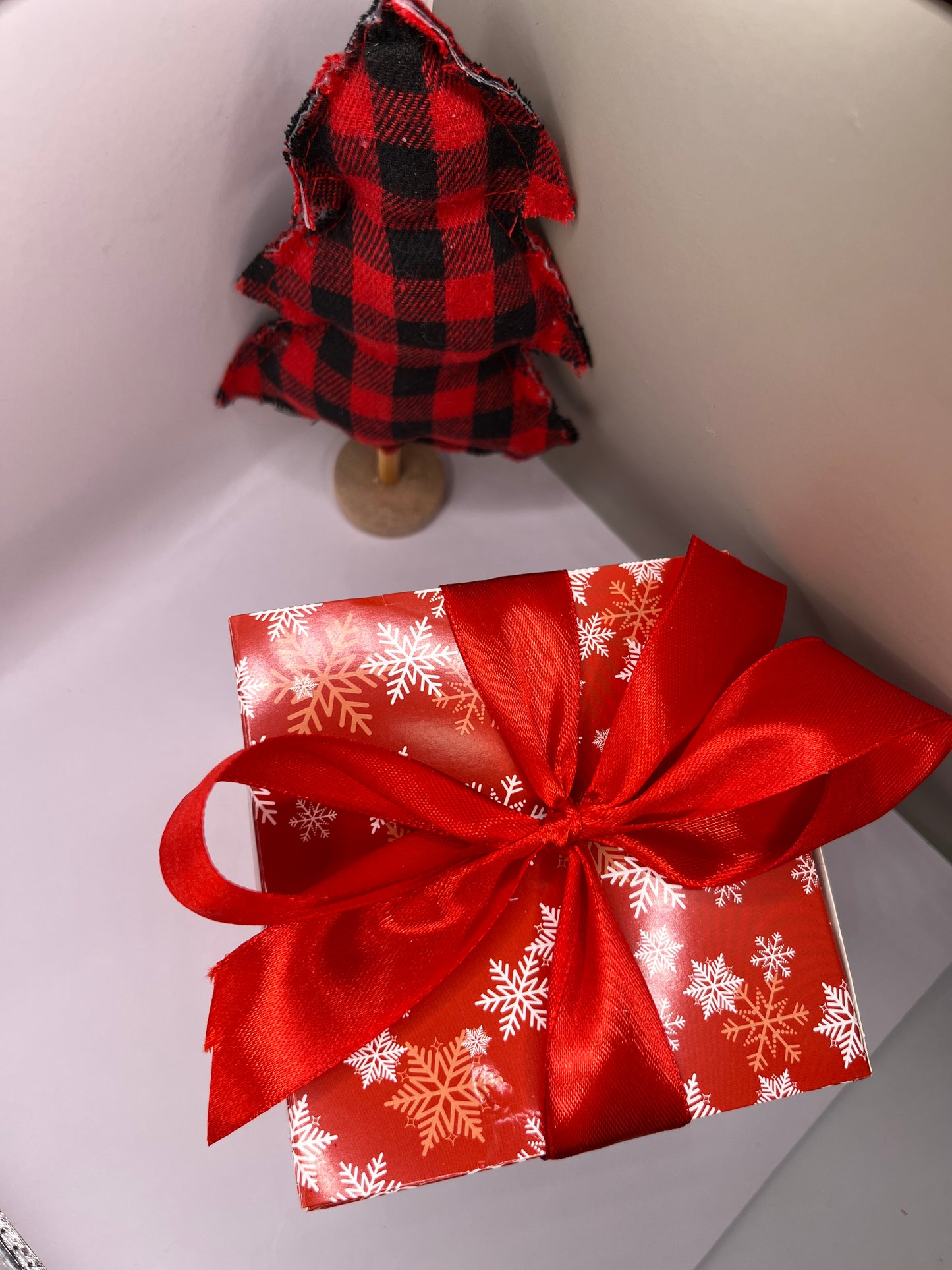 Red square box with snowflakes and red ribbon. 